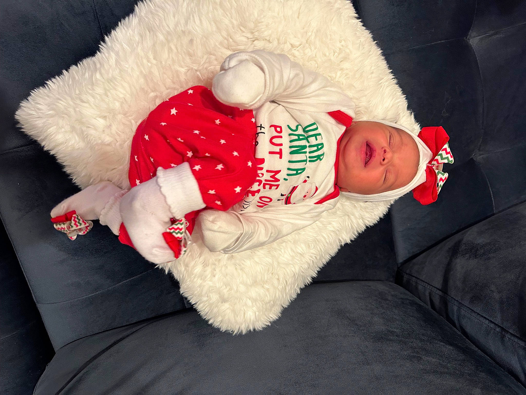 Ariana joined the competition — help win amazing prizes! arm, baby, baby_sleeping, baby_toddler_clothing, carmine, christmas, comfort, costume_hat, couch, fur, hat, holiday, human_body, lap, linens, person, sitting, sleeve, textile, thigh