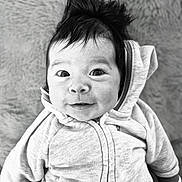 Mélio participe au concours pour gagner de l'argent avec cette photo : baby, infant, child, portrait, black_and_white, hoodie, hair, smile, eyes, face, blanket, texture, closeup, cute, cozy, lying_down, looking_at_camera, jacket, adorable, expression