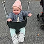 baby, infant, child, swing, playground, beanie, smile, puffy_jacket, booties, mittens, stroller, asphalt, concrete_wall, chain, swing_seat, hands, outdoors, cold_weather, happy, cute