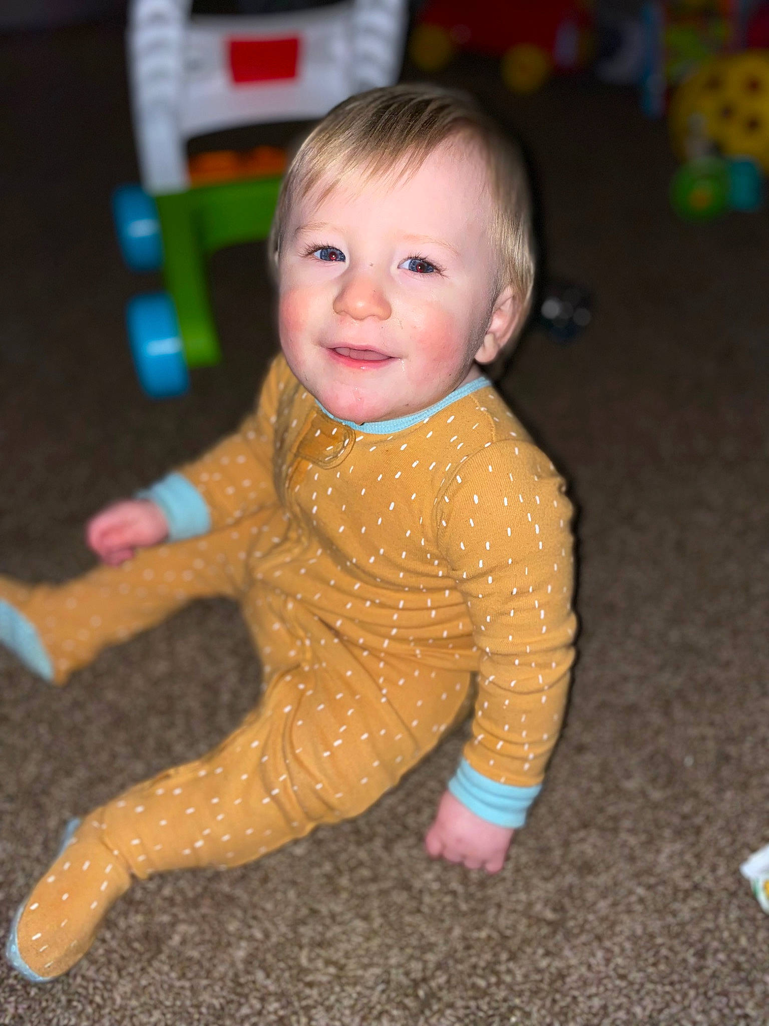 Malachai is registered to the contest to win money with this photo: baby, baby_toddler_clothing, cheek, child, eye, face, facial_expression, floor, flooring, fun, happy, head, human_body, joy, leg, nose, person, skin, sleeve, smile