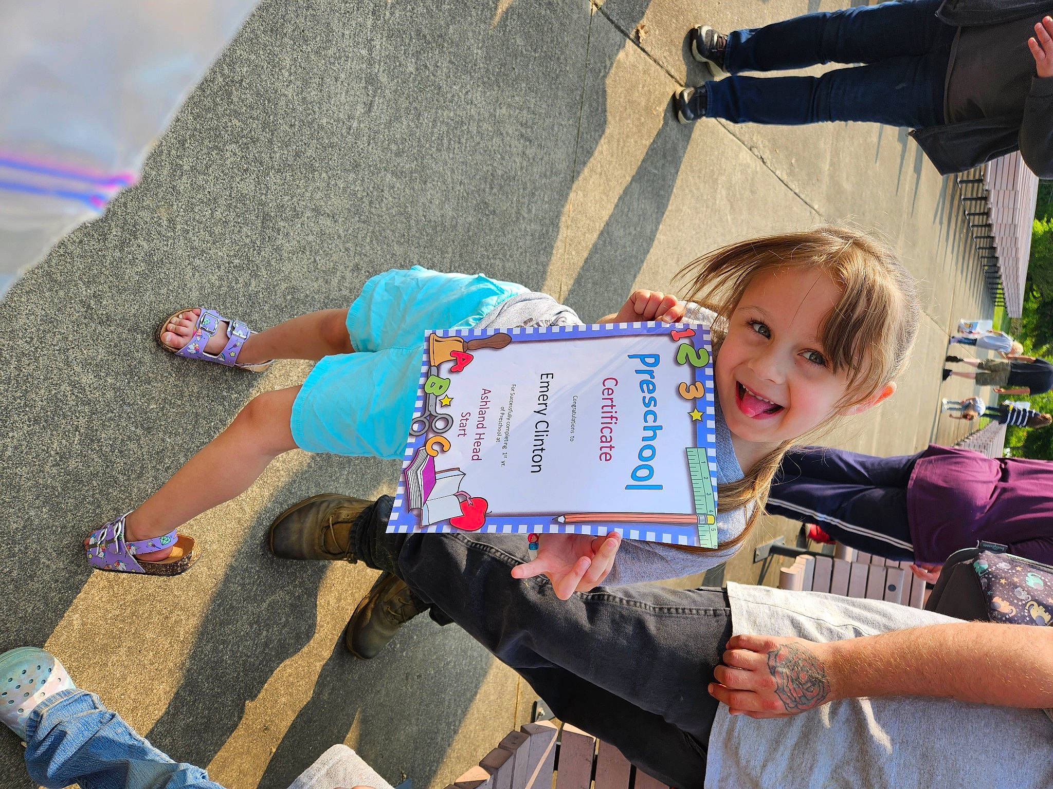 Emery is registered to the contest to win money with this photo: asphalt, child, electric_blue, event, fun, grass, happy, human_leg, joy, knee, leisure, person, play, recreation, road_surface, sitting, smile, snapshot, thigh, toddler