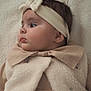 baby, infant, headband, profile, face, clothing, beige, soft_texture, warm, cute, child, portrait, indoor, closeup, adorable, newborn, cozy, young, expression, gaze