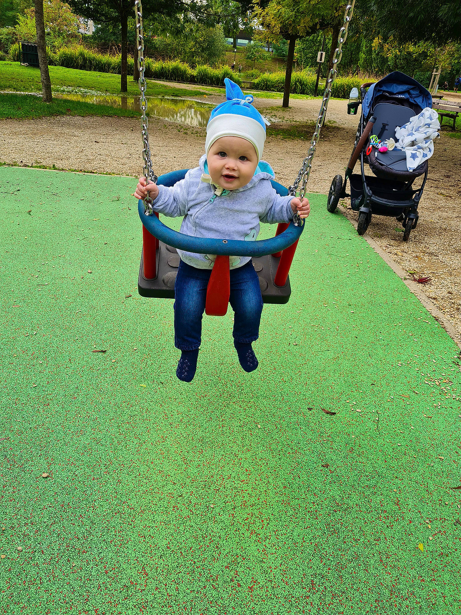 Adrian a rejoint le concours — aidez-le/la à gagner de superbes lots ! asphalt, baby, electric_blue, fun, grass, green, headwear, jacket, lawn, leisure, outdoor_play_equipment, people_in_nature, person, plant, playground, recreation, soil, swing, tire, toddler