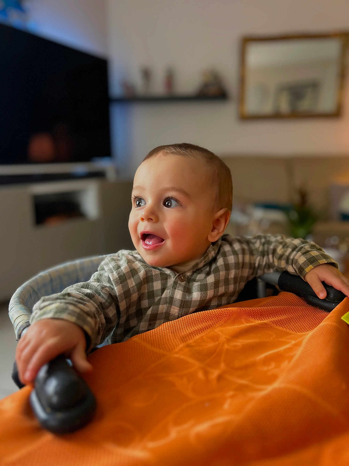 Ezio a rejoint le concours — aidez-le/la à gagner de superbes lots ! baby, infant, toddler, child, portrait, smiling, checkered_shirt, highchair, hands, eyes, cheeks, indoors, living_room, bokeh, warm_lighting, furniture, tablecloth, curiosity, candid, young