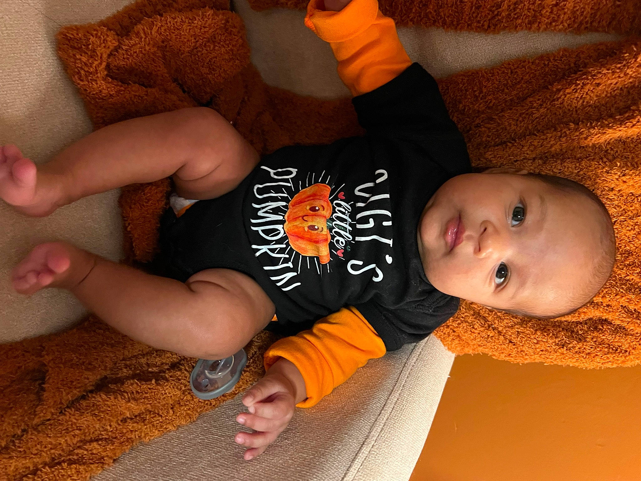 Avani joined the competition — help win amazing prizes! baby_toddler_clothing, cheek, child, comfort, elbow, facial_expression, finger, flooring, hairstyle, hand, human_body, human_leg, orange, person, sitting, skin, sleeve, thigh, thumb, toddler