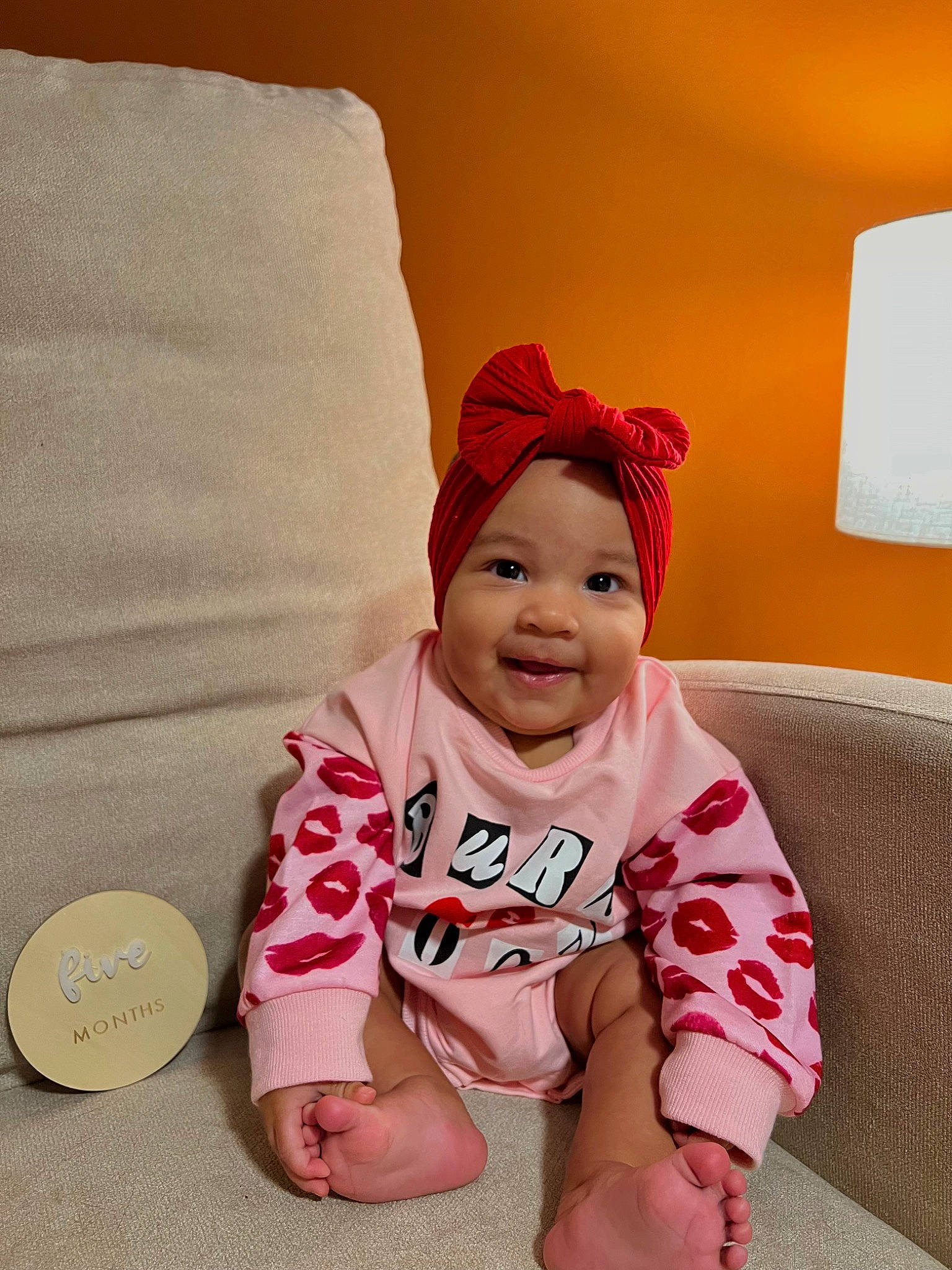 Avani joined the competition — help win amazing prizes! baby, baby_toddler_clothing, cap, carmine, child, comfort, couch, flooring, foot, happy, headwear, joy, knee, lamp, linens, person, sitting, sleeve, smile, t_shirt