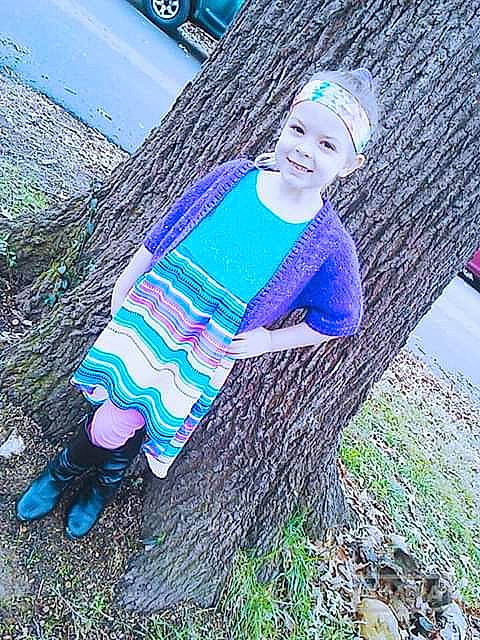 Jaylin is registered to the contest to win money with this photo: beanie, blue, child, grass, joy, knitting, pattern, person, photography, plant, purple, textile, tree, vacation