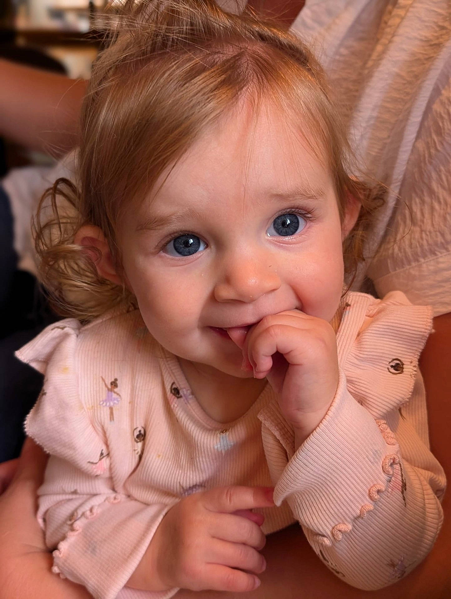 Sienna is registered to the contest to win money with this photo: accessories, baby, biting, bodypart, couch, eating, face, finger, food, furniture, hand, happy, head, jewelry, mouth, necklace, person, photography, portrait, smile