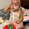 Anahi joined the competition — help win amazing prizes! baby, child, pacifier, feeding_tube, headband, flower, pink_clothing, toy, bed, pillow, blanket, cute, indoor, infant, sitting, portrait, expression, skin, hand, face