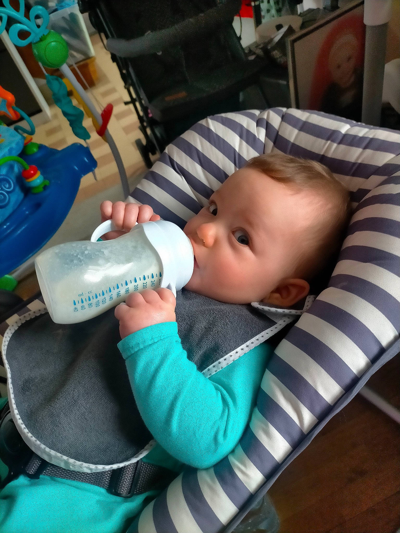 Maé participe au concours pour gagner de l'argent avec cette photo : baby, baby_carriage, baby_products, baby_toddler_clothing, car_seat, chair, cheek, child, comfort, drinkware, flooring, person, product, room, sitting, skin, toddler, wood