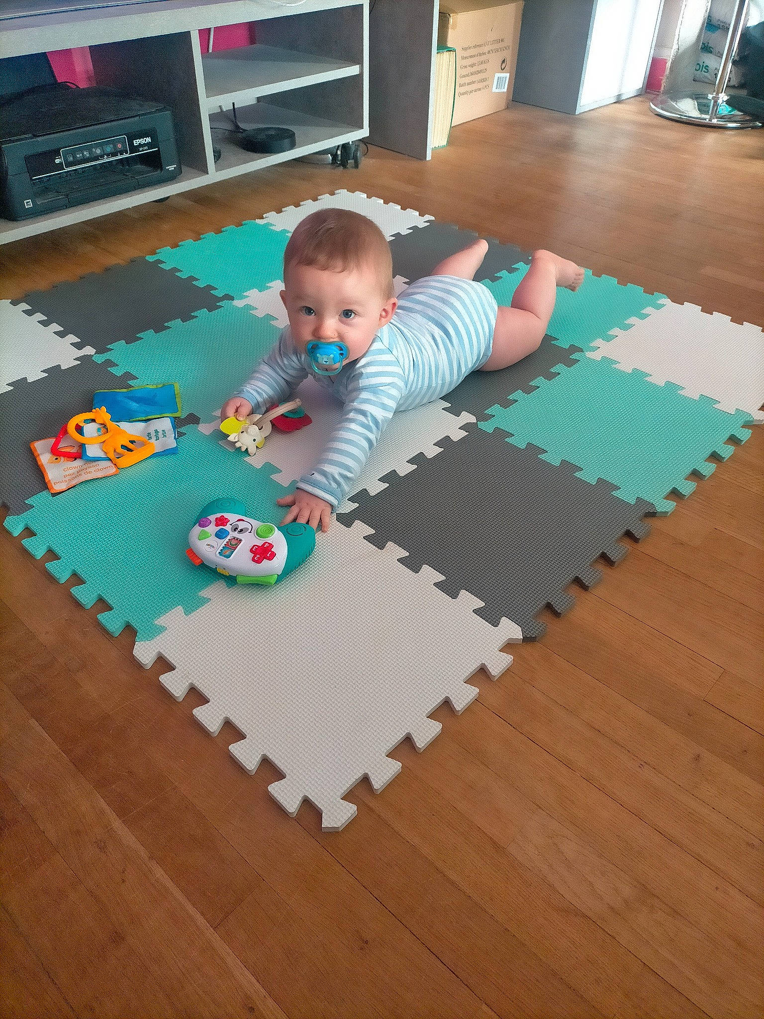 Maé a rejoint le concours — aidez-le/la à gagner de superbes lots ! baby, carpet, child, computer_keyboard, crawling, floor, flooring, hardwood, laminate_flooring, linens, mat, pattern, person, rectangle, room, textile, toddler, toy, wood, wood_flooring