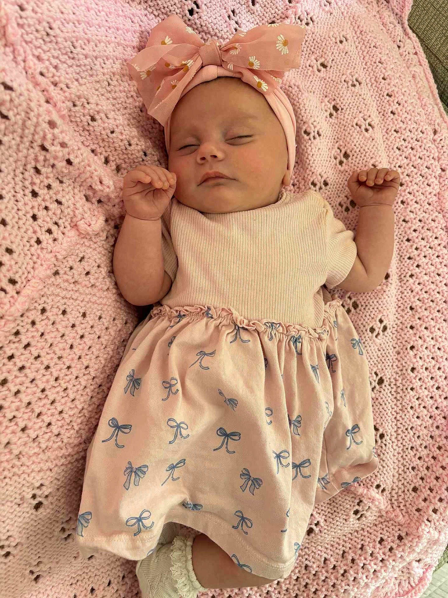 Skyla is registered to the contest to win money with this photo: baby, sleeping, pink, headband, bow, blanket, knitted, cute, infant, child, soft, clothing, pattern, peaceful, resting, small, hands, feet, white_socks, portrait
