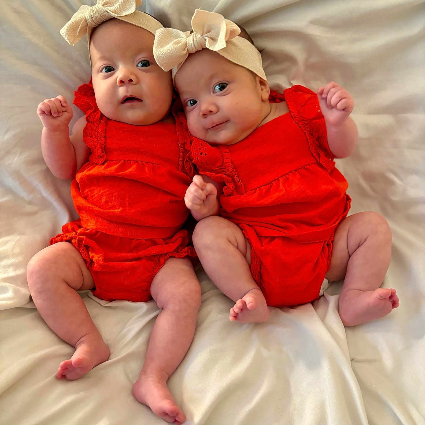 Selah And Alujah joined the competition — help win amazing prizes! baby, bed, blanket, bow, child, cute, happy, headband, indoors, infant, lying_down, newborn, orange_clothing, person, portrait, skin, small_fingers, smile, soft_texture, twin