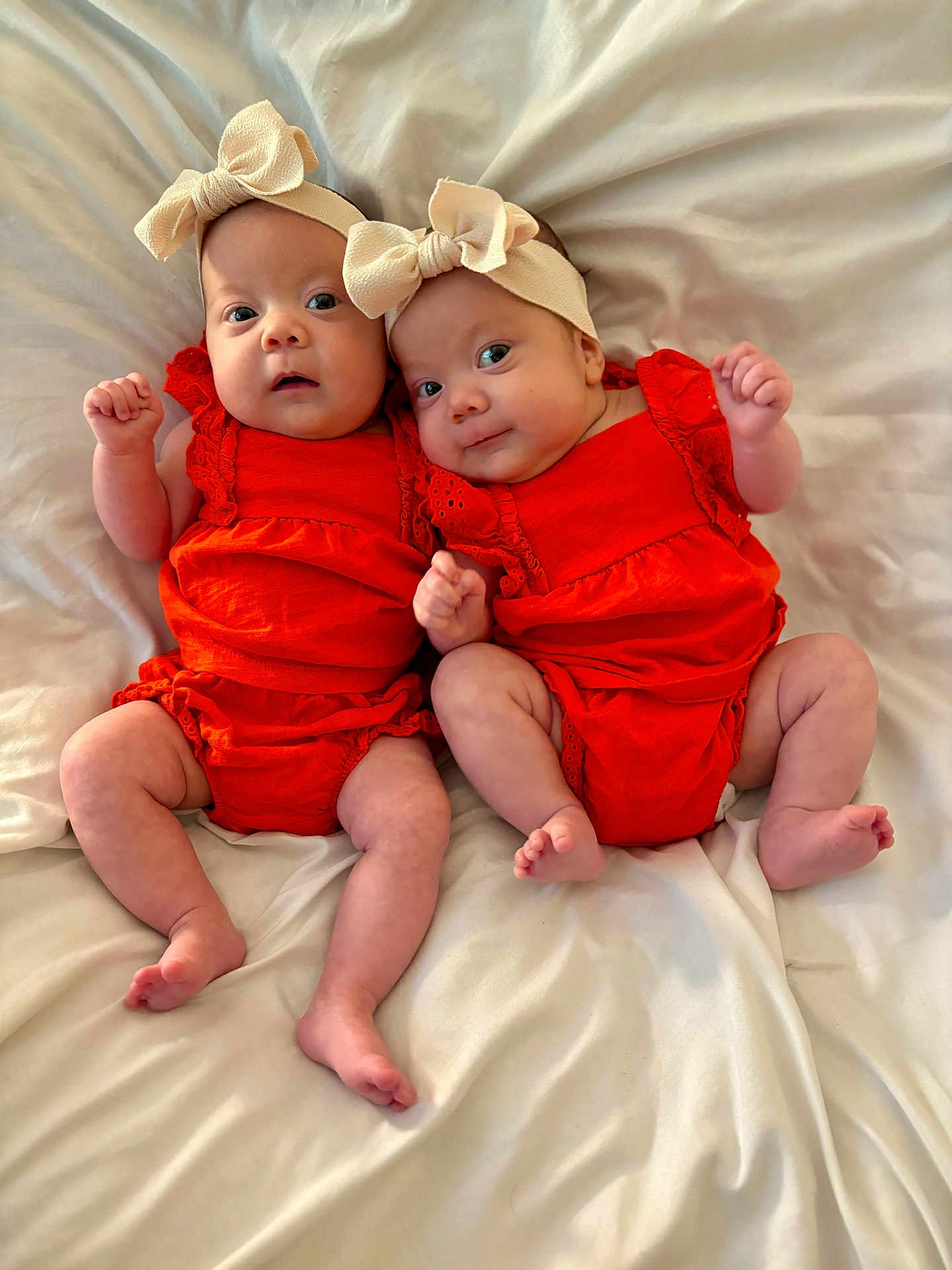 Selah And Alujah joined the competition — help win amazing prizes! baby, infant, twin, headband, bow, orange_clothing, blanket, bed, lying_down, cute, newborn, child, person, skin, smile, happy, indoors, portrait, small_fingers, soft_texture