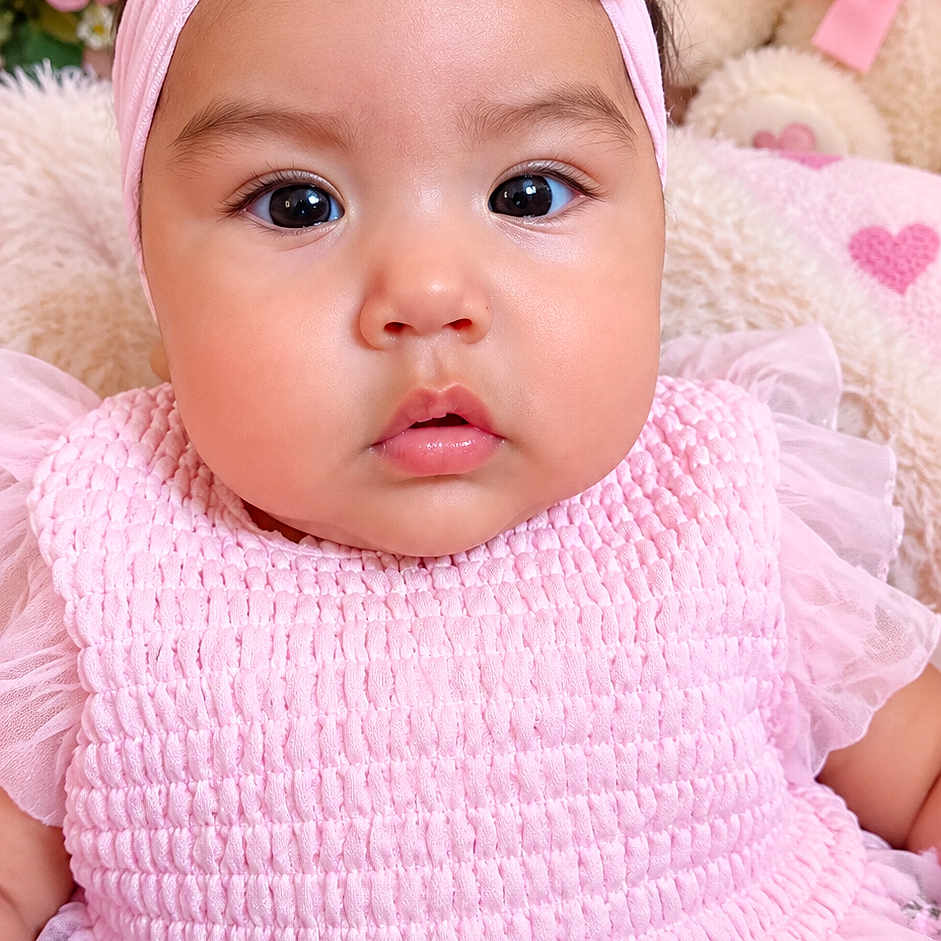 Eilany Campos is registered to the contest to win money with this photo: baby, child, infant, portrait, pink, dress, bow, headband, smiling, wide_eyed, face, indoors, floral, flowers, teddy_bear, stuffed_animal, nursery, closeup, fashion, cute