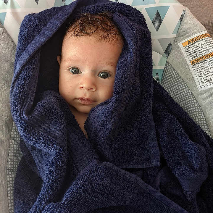 Jarvis joined the competition — help win amazing prizes! baby, blanket, bonnet, clothing, cushion, face, hat, head, homedecor, hood, hoodie, knitwear, newborn, person, photography, portrait, sweater, sweatshirt, text, towel