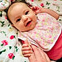 Addison joined the competition — help win amazing prizes! baby, smiling, infant, hand_holding, floral_blanket, bib, pink_clothing, happy, closeup, cute, child, face, skin, person, indoors, comfort, touch, expression, young, portrait