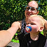 Adeline is registered to the contest to win money with this photo: baby, toddler, child, adult, parent, selfie, outdoor, forest, greenery, nature, sunglasses, eyeglasses, pacifier, black_clothing, portrait, family, face, smiling, sunlight, close_up