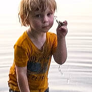 Blake joined the competition — help win amazing prizes! boy, casual_clothing, child, curious, daylight, nature, orange_shirt, outdoor, person, play, portrait, reflection, ripples, small_object, standing, summer, water, water_drip, wet_hair, young