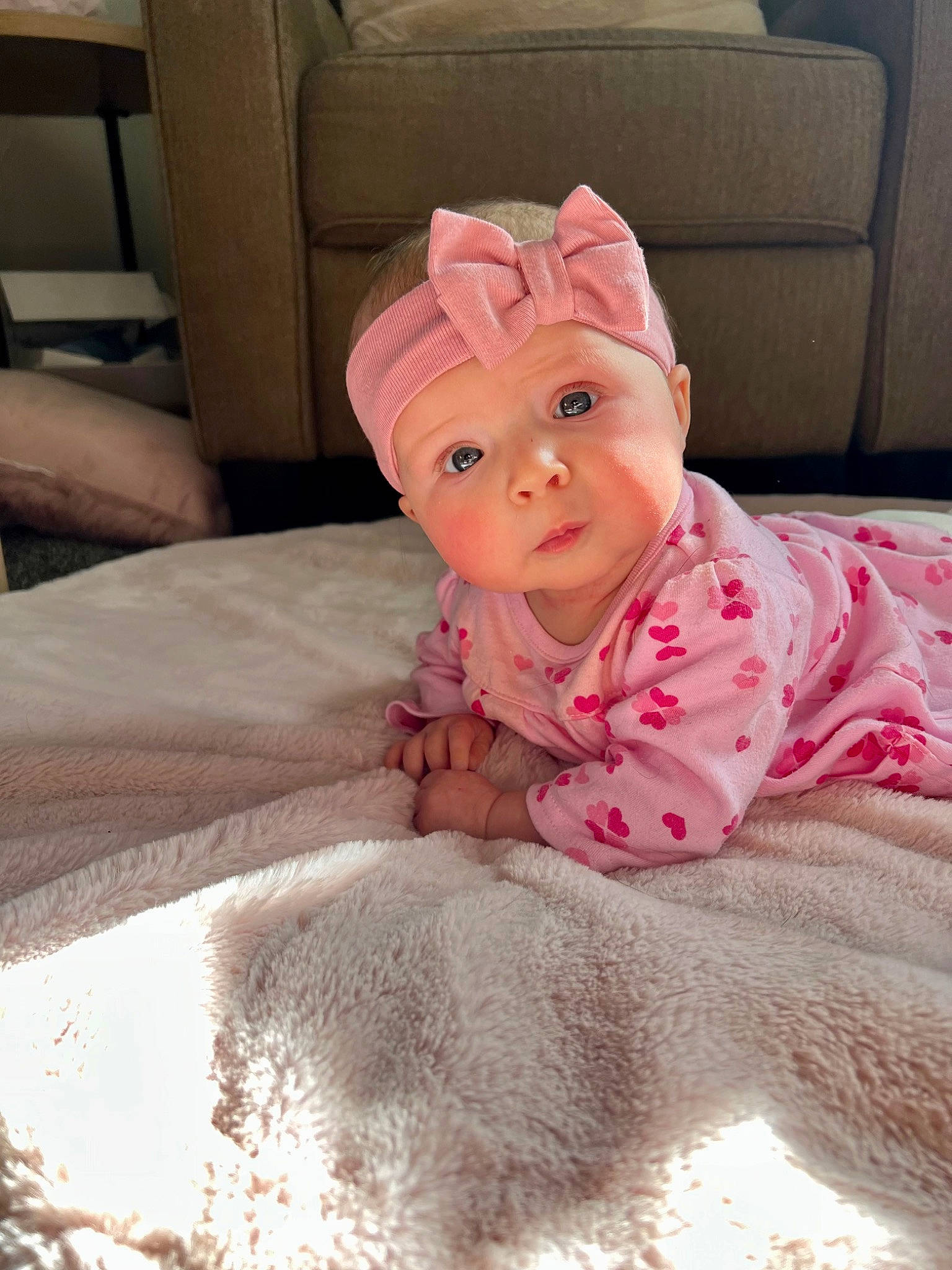 Ella is registered to the contest to win money with this photo: baby, baby_toddler_clothing, bed, bed_sheet, bedding, child, comfort, couch, flooring, fur, headwear, linens, magenta, person, pink, room, skin, sleeve, stuffed_toy, toddler