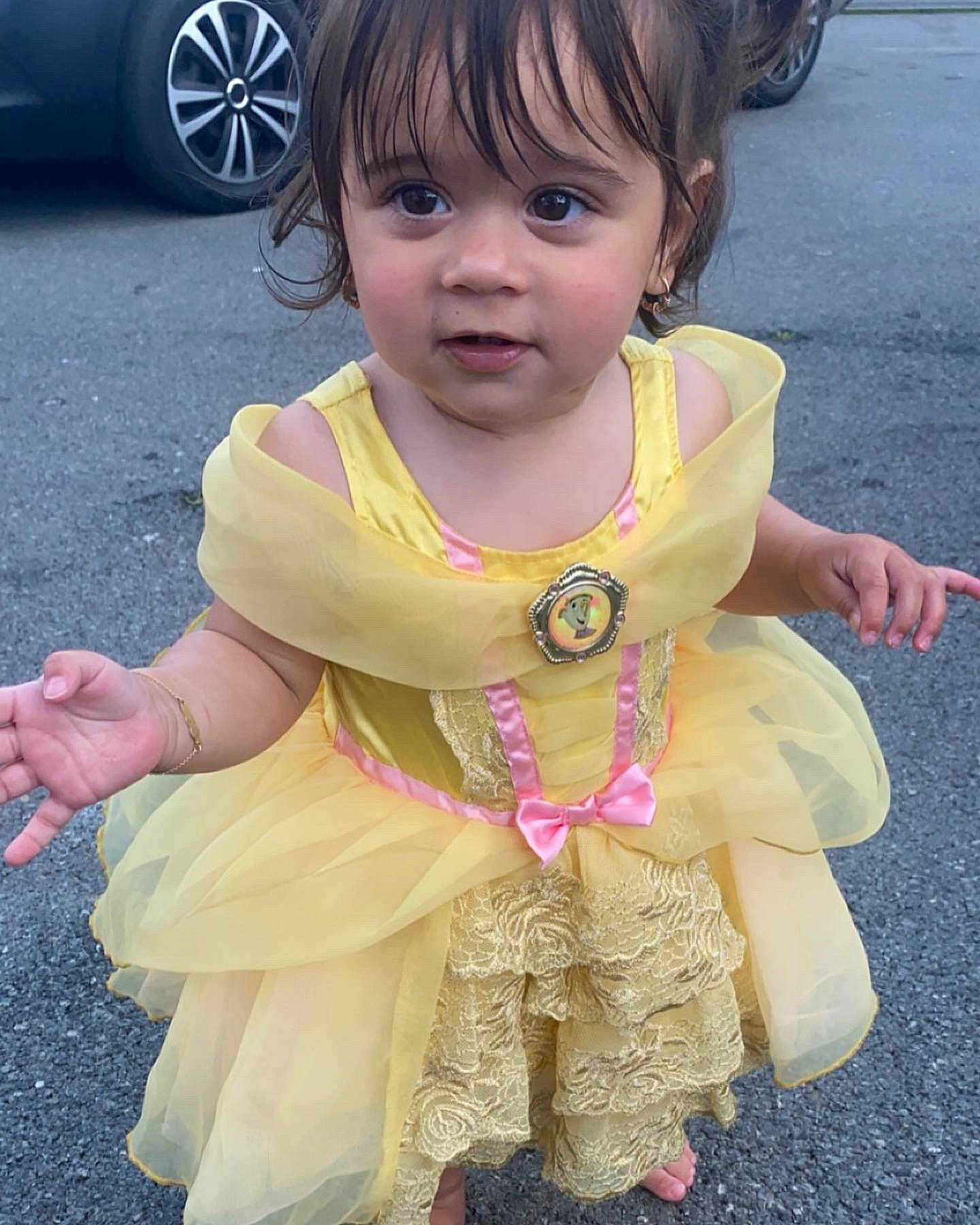 Léna participe au concours pour gagner de l'argent avec cette photo : asphalt, automotive_tire, baby_toddler_clothing, blue, dress, eye, face, hairstyle, happy, head, iris, person, photograph, pink, skin, sleeve, smile, tire, toddler, wheel