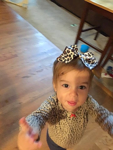 Colette is registered to the contest to win money with this photo: baby, baby_toddler_clothing, child, costume_accessory, crawling, fashion_accessory, floor, flooring, hair_accessory, hardwood, headgear, headpiece, laminate_flooring, long_sleeved_t_shirt, pattern, person, tile, toddler, varnish, wood_flooring