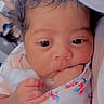 Legacy joined the competition — help win amazing prizes! baby, infant, face, hand, blanket, floral_pattern, curly_hair, cute, skin, newborn, portrait, sucking_fist, closeup, soft_lighting, indoor, cozy, child, wrapped, young, toddler