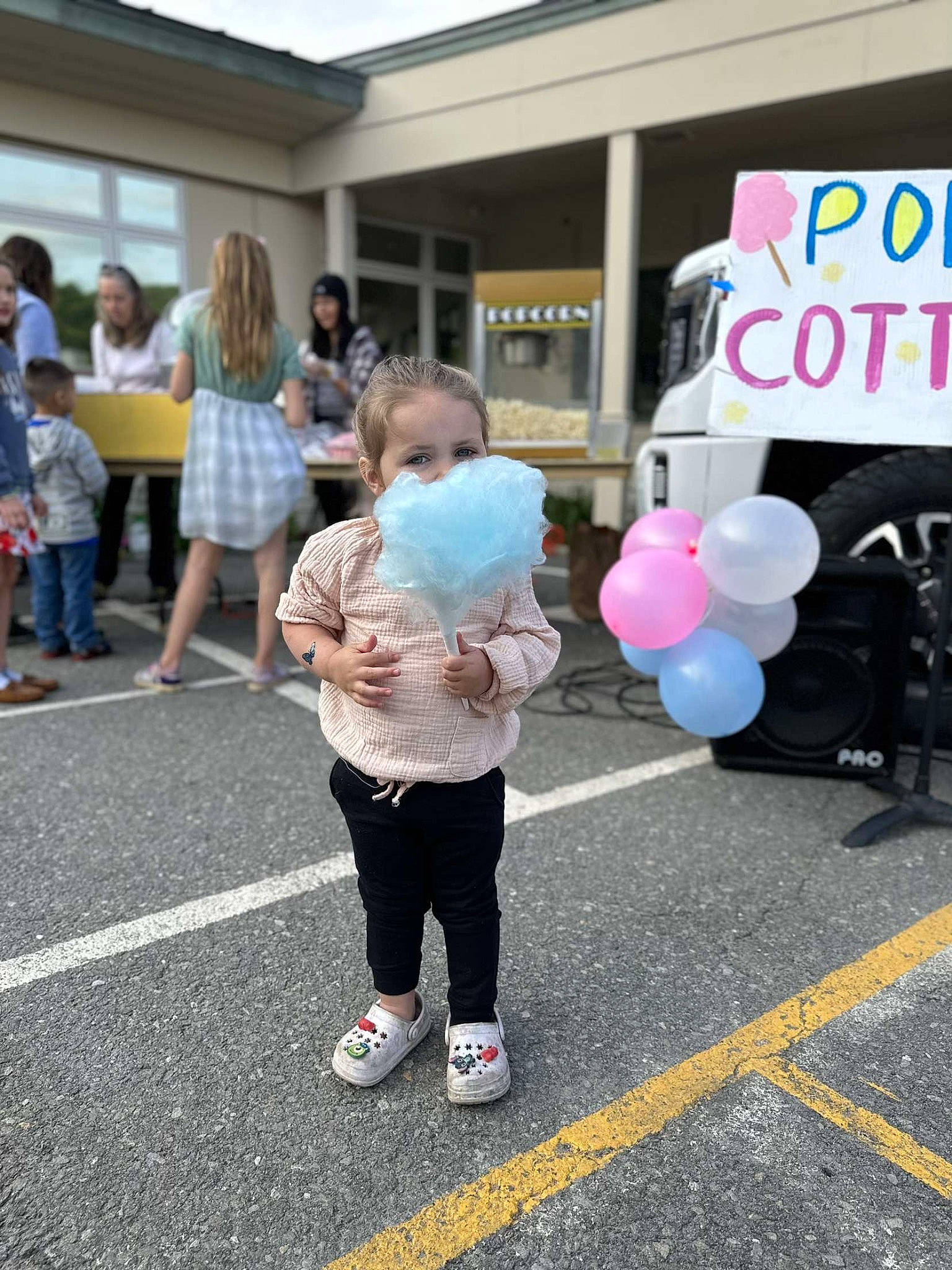Marianna is registered to the contest to win money with this photo: balloon, blurred, child, city, costume, crowd, event, fun, leisure, party_supply, pedestrian, person, pink, public_event, public_space, recreation, road, shorts, street, t_shirt