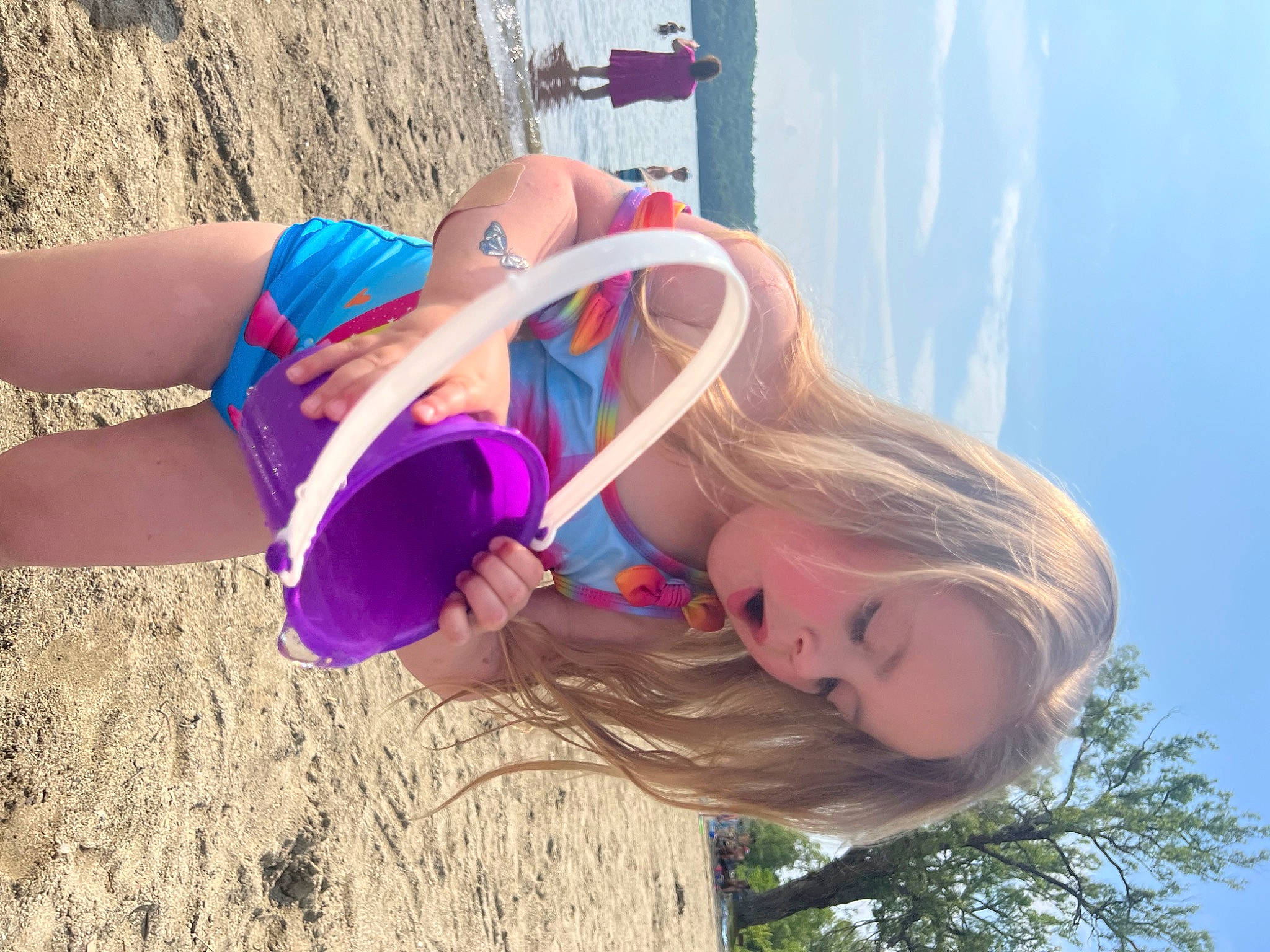 Marianna is registered to the contest to win money with this photo: azure, beach, blond, electric_blue, eyewear, face, fun, grass, happy, landscape, leisure, long_hair, people_in_nature, person, pink, sky, swimwear, thigh, travel, tree