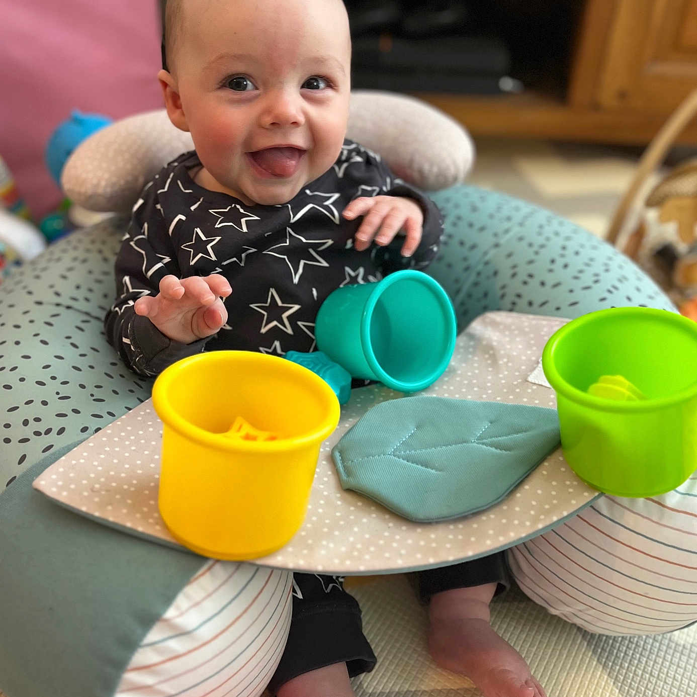 Jenson joined the competition — help win amazing prizes! baby, baby_seat, carpet, child, clothing, colorful_toys, cushion, cute, face, feet, happy, indoor, infant, person, plastic_cups, playtime, smiling, star_pattern, tongue_out, toy