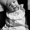 baby, child, black_and_white, bow, dress, embroidery, cute, portrait, sitting, infant, clothing, sock, legs, face, headwear, adorable, expression, closeup, seat, monochrome
