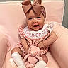 baby, child, infant, pink, bow, headband, stuffed_toy, bunny, armchair, bib, clothing, socks, smile, happy, cute, indoor, portrait, soft_texture, seated, young