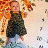 Aiden joined the competition — help win amazing prizes! baby, infant, child, blanket, giraffe, pattern, numbers, camouflage, clothing, orange, green, face, skin, lying_down, cute, indoors, soft_texture, decor, plants, portrait