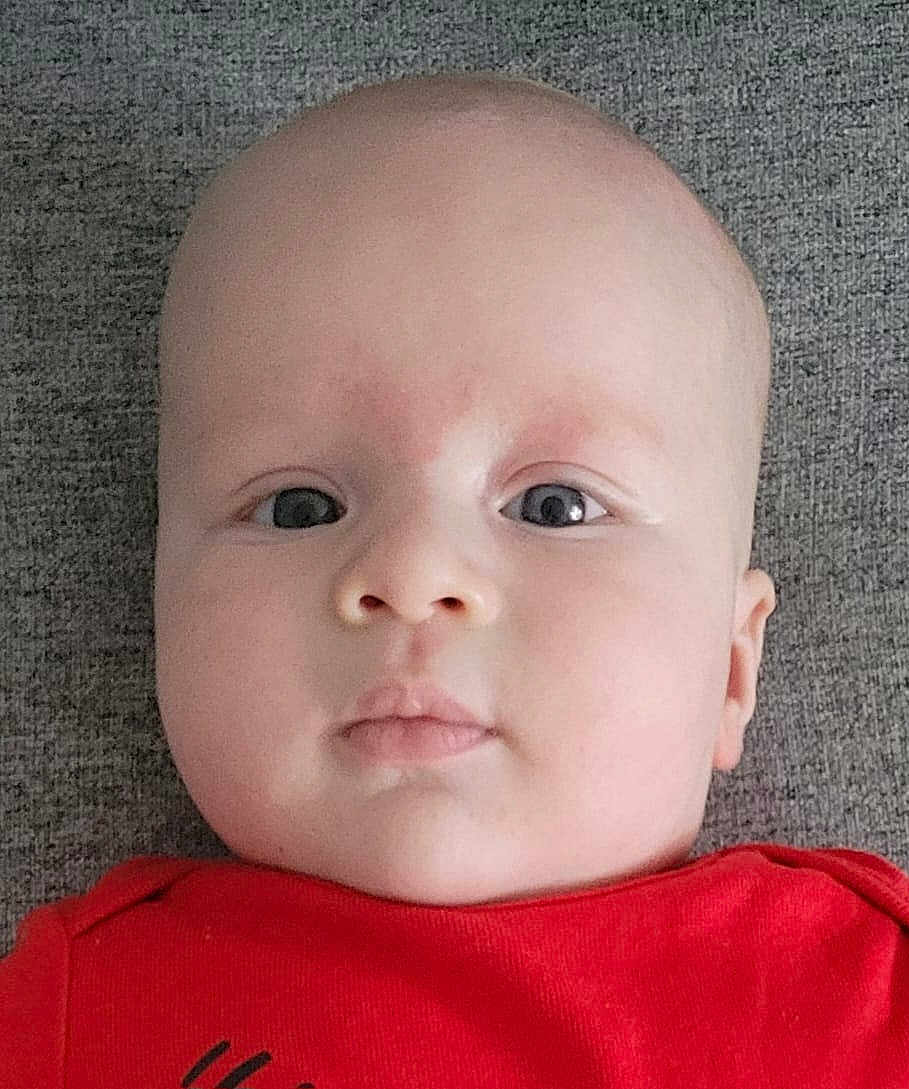 Aylan participe au concours pour gagner de l'argent avec cette photo : baby, infant, face, head, eyes, skin, red_clothing, portrait, closeup, child, young, person, expressionless, lying_down, indoors, texture, soft, cute, human, newborn