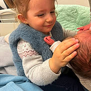 Kessy participe au concours pour gagner de l'argent avec cette photo : child, baby, newborn, toddler, girl, pigtails, smiling, caring, hand, face, blanket, clothing, indoor, bed, soft, warm, family, love, gentle, comfort