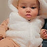 Rosalise is registered to the contest to win money with this photo: baby, child, clothing, cute, expression, eyes, face, hand, hood, indoors, infant, lips, nose, pajamas, portrait, seated, skin, soft_texture, warm, white_fur