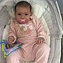 baby, infant, pacifier, pink_clothing, baby_bed, fabric_book, cute, child, indoor, soft_toys, comfortable, smiling, young, person, pajamas, face, head, hand, foot, seat