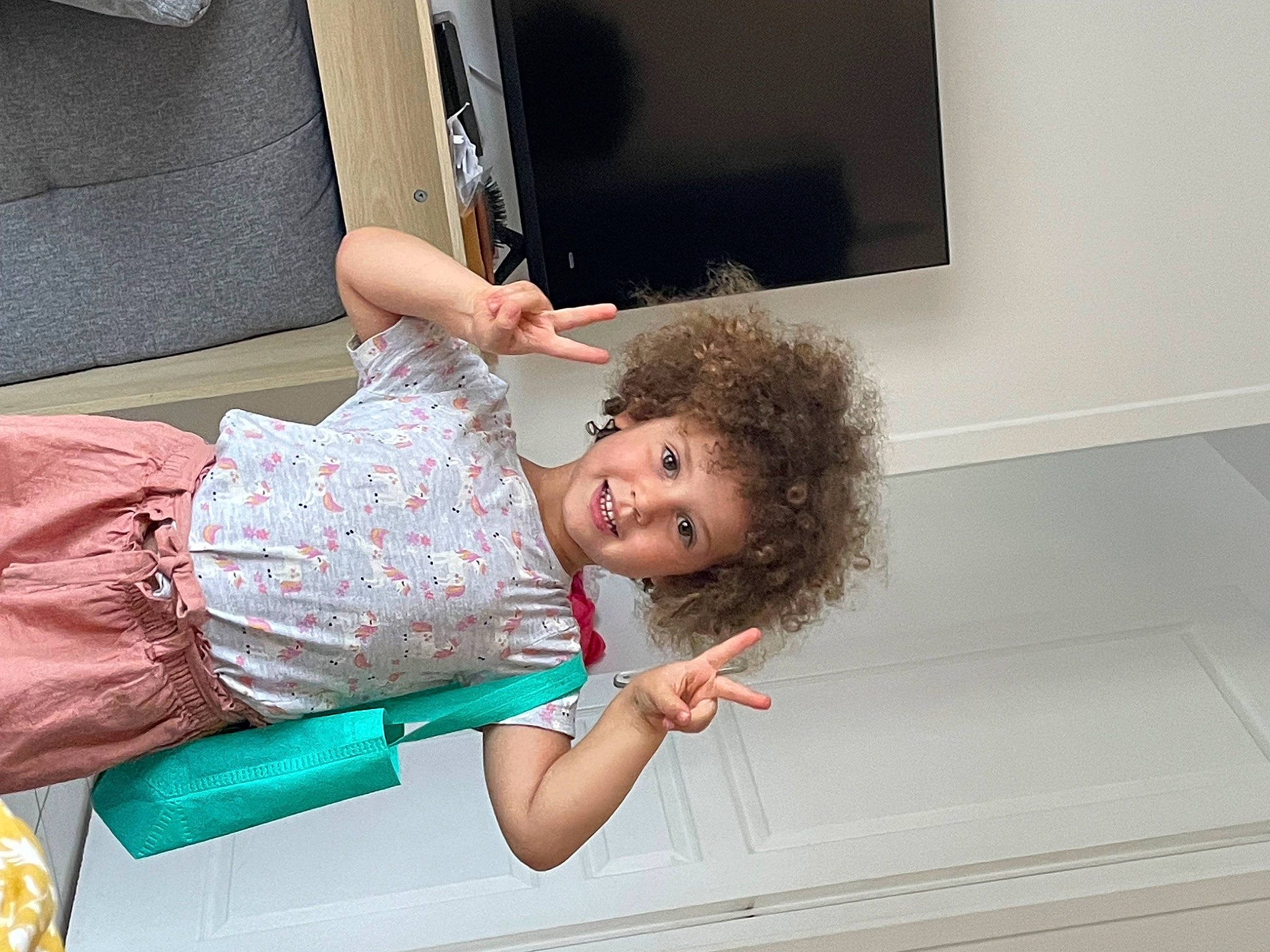 Elena participe au concours pour gagner de l'argent avec cette photo : child, comfort, display_device, elbow, flooring, fun, happy, home_appliance, joint, joy, led_backlit_lcd_display, leisure, person, room, sitting, smile, t_shirt, television, television_set, toddler