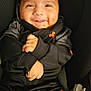 baby, child, smiling, black_clothing, under_armour, car_seat, happy, portrait, infant, cute, seatbelt, young_child, sitting, indoors, cozy, hands, face, head, warm, casual_wear