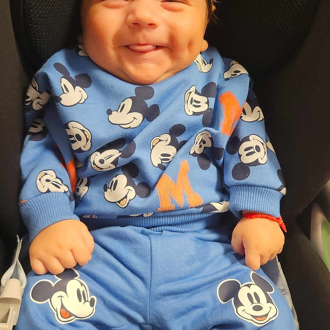 Antonio a rejoint le concours — aidez-le/la à gagner de superbes lots ! baby, blue_clothing, car_seat, casual, child, clothing_pattern, cozy, cute, dimple, happy, indoors, infant, mickey_mouse, person, playful, portrait, seated, smiling, tongue_out, young_child