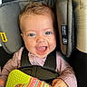 baby, child, car_seat, smiling, blue_eyes, toy, striped_clothing, seatbelt, infant, happy, close_up, face, cute, indoor, safety, colorful, hand, hair, person, protection