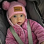 baby, button, car_seat, child, cute, face, hand, headwear, indoor, infant, jacket, person, pink_hat, pom_poms, portrait, safety_straps, soft_texture, warm_clothing, wide_eyes, winter_clothing