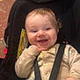 baby, child, car_seat, smiling, happy, blanket, indoor, seatbelt, clothing, hand, face, person, cute, infant, playful, cheerful, young, safety, seat, expression