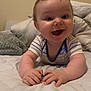 Noah is registered to the contest to win money with this photo: baby, child, smiling, happy, bed, blanket, pillow, infant, cute, person, indoor, striped_clothing, toddler, skin, head, hand, face, young, expression, cozy