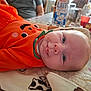 Jeanne a rejoint le concours — aidez-le/la à gagner de superbes lots ! baby, orange_outfit, smiling, blanket, face, person, table, milk_carton, coca_cola_bottle, indoor, soft_toy, close_up, head, blue_eyes, infant, clothing, domestic, relaxed, cute, portrait