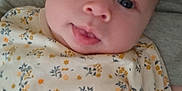 Jeanne participe au concours pour gagner de l'argent avec cette photo : baby, infant, face, tongue, blue_eyes, floral_pattern, onesie, clothing, person, adult, gray_sweatshirt, close_up, skin, head, cute, expression, child, human, portrait, indoor