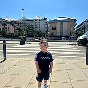 Léo a rejoint le concours — aidez-le/la à gagner de superbes lots ! child, boy, sidewalk, adidas, sportswear, sneakers, urban, crosswalk, daylight, buildings, palm_trees, street, shadow, outdoor, casual, shorts, tshirt, person, sky, photography