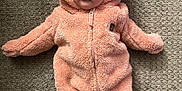 Wrainy is registered to the contest to win money with this photo: adorable, baby, carpet, child, clothing, cozy, cute, ears, fluffy, hood, indoor, infant, lying_down, onesie, person, pink, portrait, soft, toddler, warm