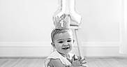 Gianna is registered to the contest to win money with this photo: baby, balloon, birthday, black_and_white, celebration, child, crown, dress, fluffy, hands, happy, indoors, infant, milestone, number_one, photography, portrait, rug, sitting, smiling