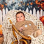 baby, infant, chair, wicker, blanket, knit, pumpkin, fall, autumn, fence, flowers, orange, brown, cozy, cute, child, portrait, indoor, seasonal, decor